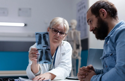 Doctor reviewing chest X-ray imaging with a patient.
